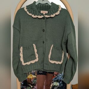 Darling Listicle Green Sweater with Cream Crochet Accents And Patch Pockets